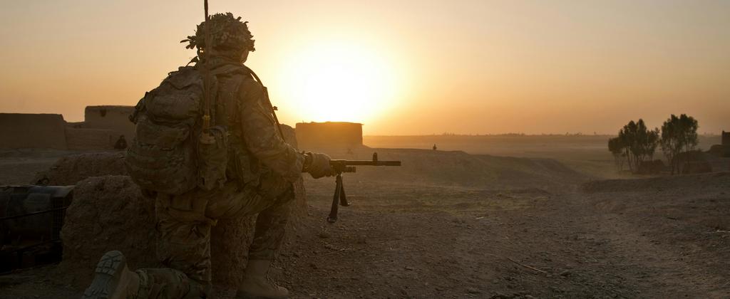 Soldier in position in desert-like terrain