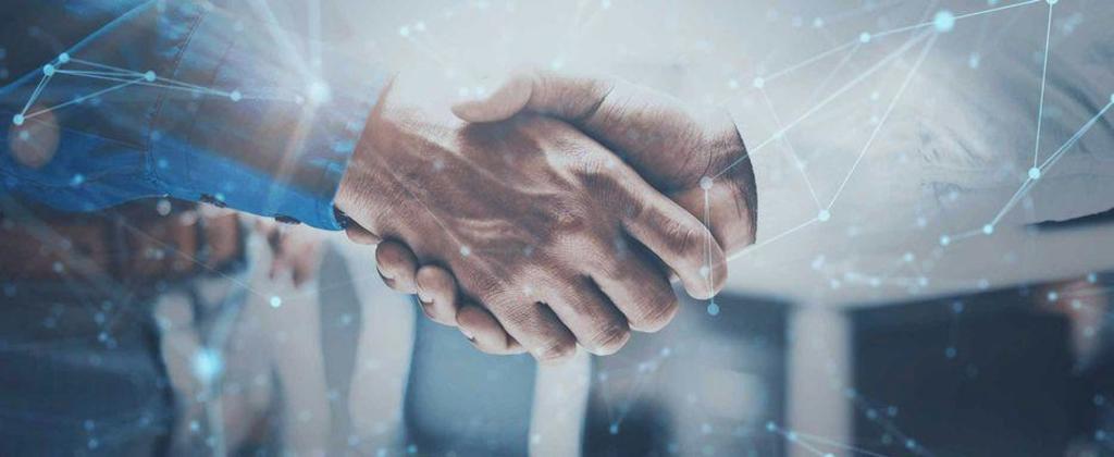 Close-up of a handshake from two men wearing business shirts. Around it you can see digital-looking dots and connecting lines. The image has a modern, technical and digital look and feel and is decorated in blue tones.