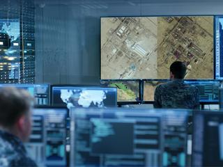 Controller collaborating on computer screens in a command centre, focused on their tasks