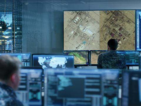 Controller collaborating on computer screens in a command centre, focused on their tasks