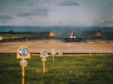 Starting airplane on a runway (view from behind)