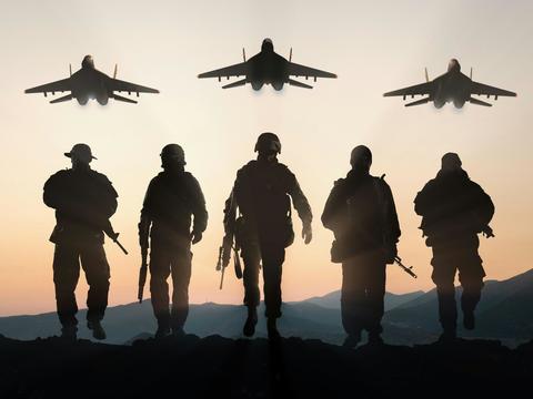 Shadows of five soldiers in a row with fighter jets in the air above them