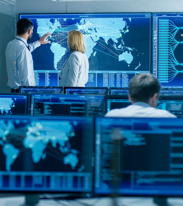 Analytics experts discussing in front of a big screen to determine solutions