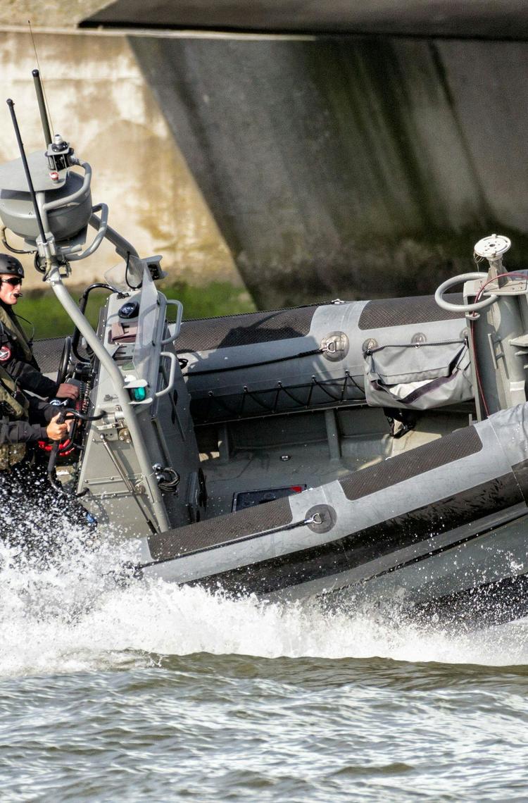 Military men navigating on a speed boat, monitoring coastal areas