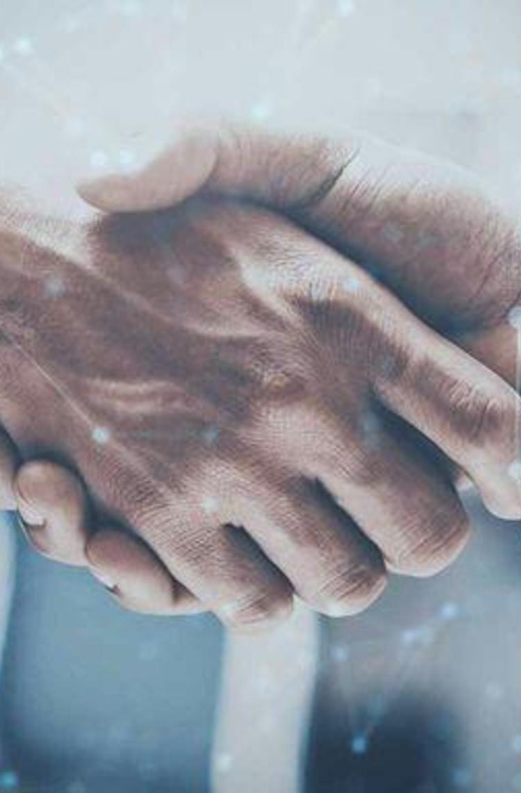 Close-up of a handshake from two men wearing business shirts. Around it you can see digital-looking dots and connecting lines. The image has a modern, technical and digital look and feel and is decorated in blue tones. Close-up of a handshake from two men wearing business shirts. Around it you can see digital-looking dots and connecting lines. The image has a modern, technical and digital look and feel and is decorated in blue tones.