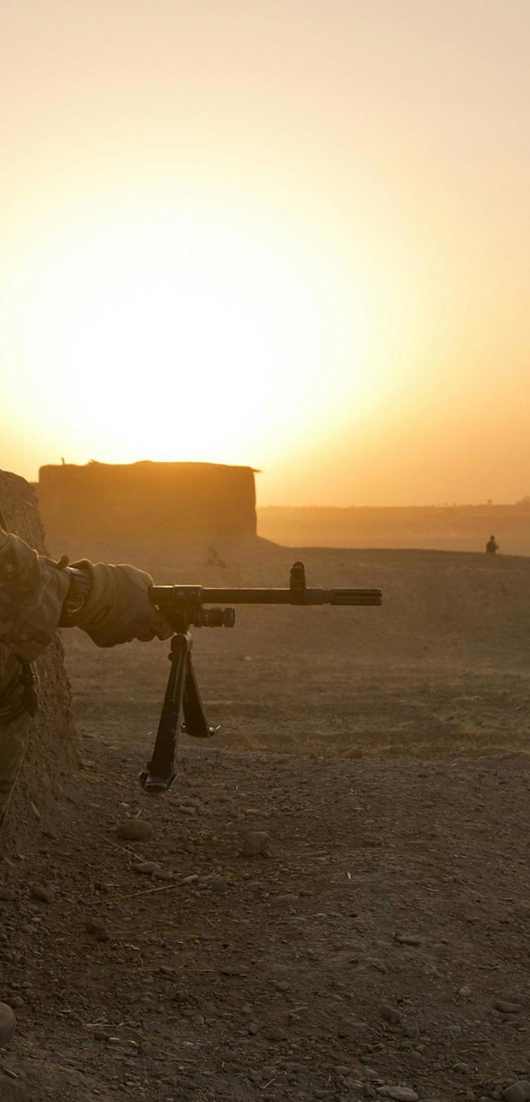 Soldier in position in desert-like terrain Soldier in position in desert-like terrain
