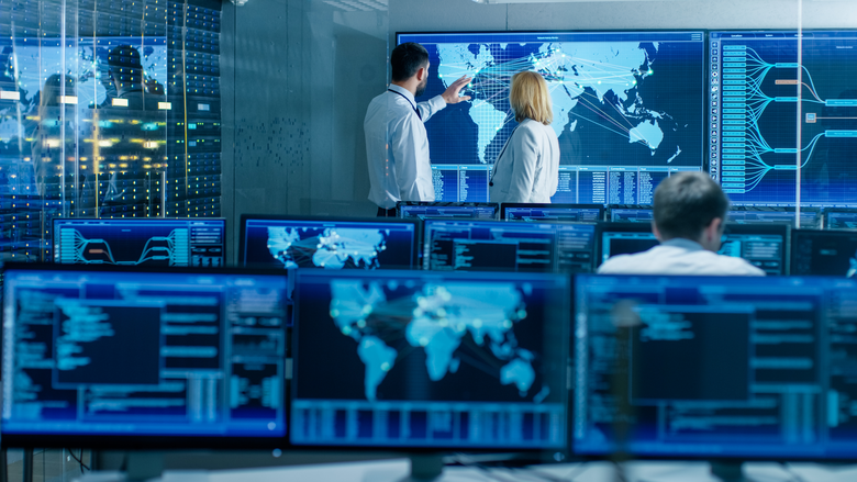 Analytics experts discussing in front of a big screen to determine solutions
